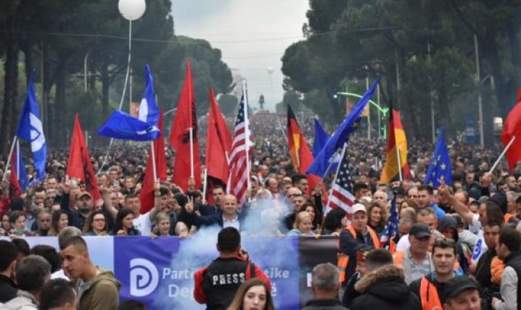 ‘Me dy gishta lart’, protestuesi hipën në ballkonin e Kuvendit, policia e shoqëron brenda